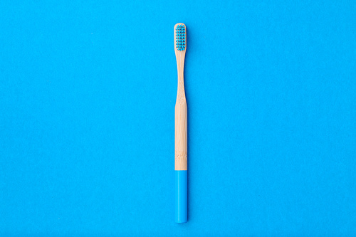 Toothbrush on blue background top view copy space. Tooth care, dental hygiene and health concept.