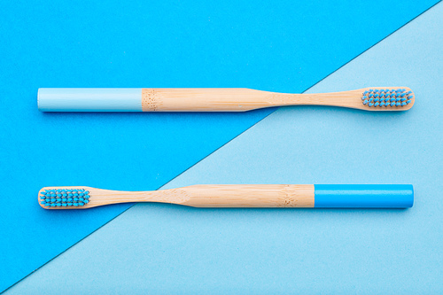 Toothbrushes on blue background top view. Tooth care, dental hygiene and health concept.