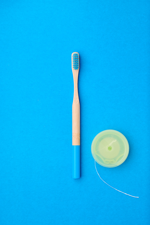 Toothbrushes and oral care tools over blue background top view copy space flat lay. Tooth care, dental hygiene and health concept.