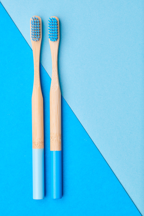 Toothbrushes on blue background top view copy space. Tooth care, dental hygiene and health concept.