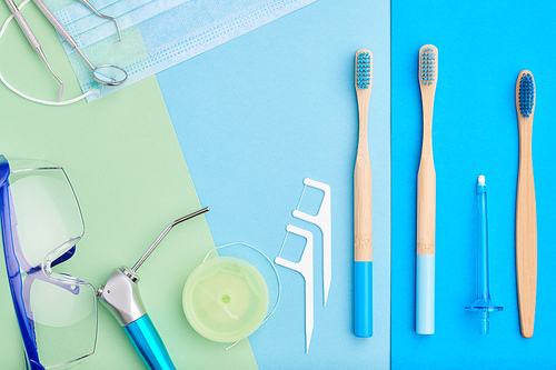 Dentist tools over blue background top view copy space flat lay. Tooth care, dental hygiene and health concept.