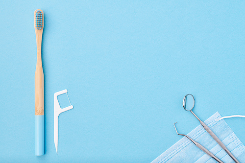 Dentist tools over light blue background top view copy space flat lay. Tooth care, dental hygiene and health concept.