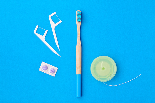 Toothbrush and oral care tools over blue background top view copy space flat lay. Tooth care, dental hygiene and health concept.