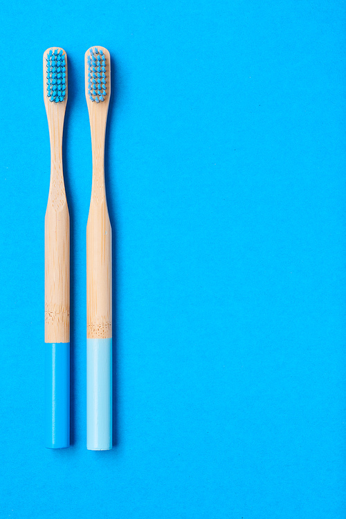 Toothbrushes on blue background top view copy space. Tooth care, dental hygiene and health concept.