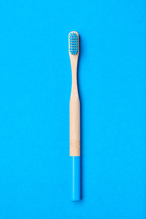 Toothbrush on blue background top view copy space. Tooth care, dental hygiene and health concept.