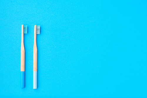 Toothbrushes on blue background top view copy space. Tooth care, dental hygiene and health concept.