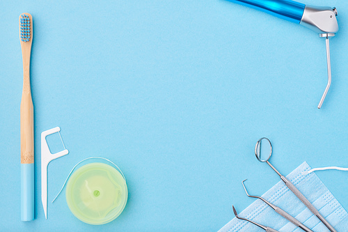 Dentist tools over light blue background top view copy space flat lay. Tooth care, dental hygiene and health concept.