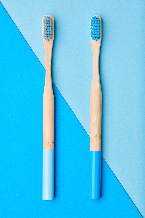 Toothbrushes on blue background top view. Tooth care, dental hygiene and health concept.