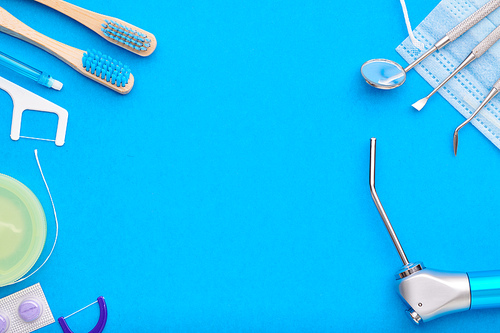 Dentist tools over blue background top view copy space flat lay. Tooth care, dental hygiene and health concept.