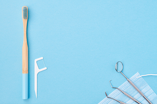 Dentist tools over light blue background top view copy space flat lay. Tooth care, dental hygiene and health concept.