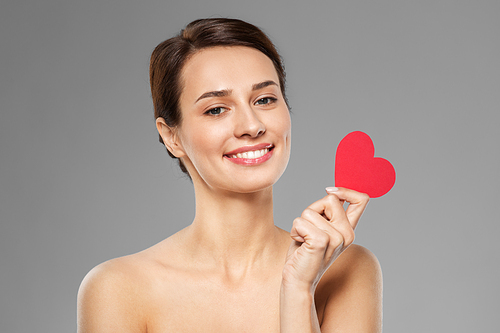 valentines day, beauty and love concept - happy smiling young woman with pink heart shape over grey background