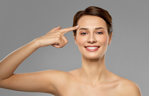 beauty, bodycare and people concept - beautiful young woman with bare shoulder over grey background