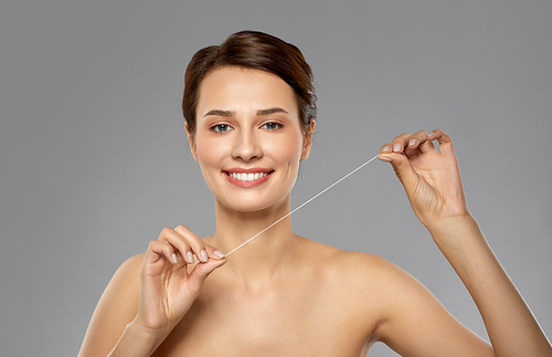 oral hygiene, dental care and health concept - happy young woman with floss cleaning teeth