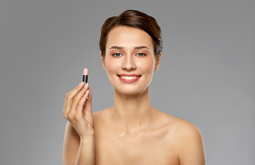 beauty, makeup and cosmetics concept - happy smiling young woman with pink lipstick over white background
