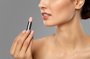 beauty, makeup and cosmetics concept - happy smiling young woman with pink lipstick over white background