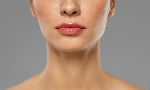 beauty, makeup and people concept - close up of beautiful young woman face and neck over grey background
