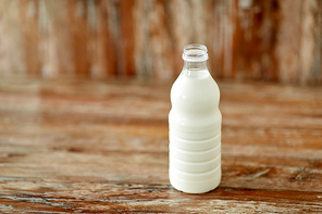 food and dairy products concept - bottle of milk on wooden table