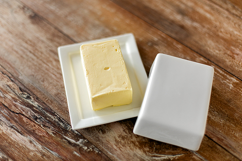 food and dairy products concept - close up of butter on wooden table