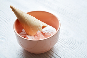 Plate of ice cream scoops and waffle cones on white background.