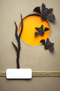 Creative halloween concept photo of bats made of paper on brown background.
