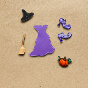 Creative halloween concept photo of witches clothes made of paper on brown background.