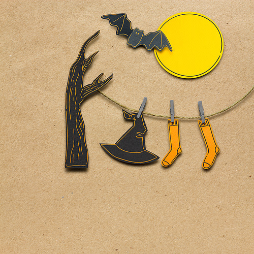 Creative halloween concept photo of witches hat and stockings made of paper on brown background.