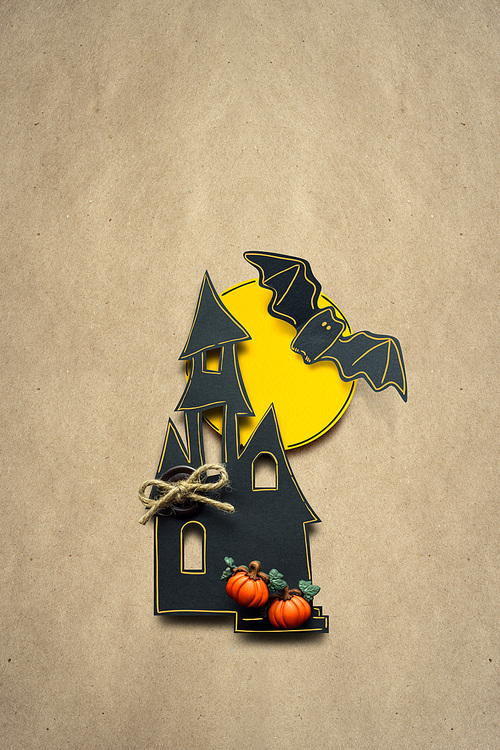 Creative halloween concept photo of a castle made of paper on brown background.
