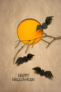 Creative halloween concept photo of bats made of paper on brown background.