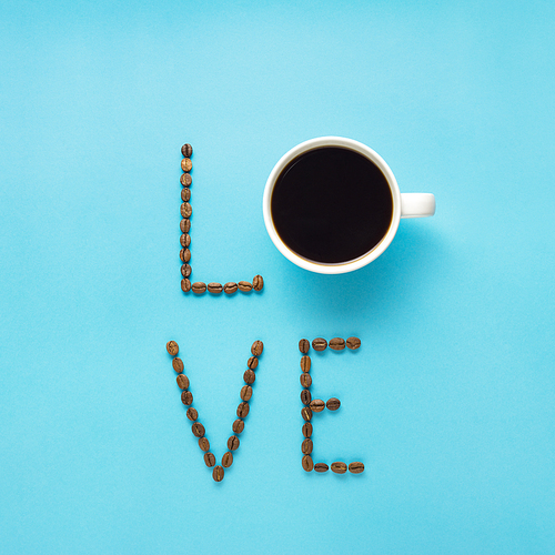 Creative concept still life valentine day holiday photo of espresso coffee cup mug drink beverage with beans seeds love text letters on blue background.