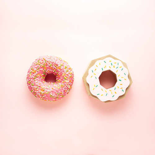 Creative concept still life health diet photo of real donut pastry dessert junk food and one made of paper on pink background.