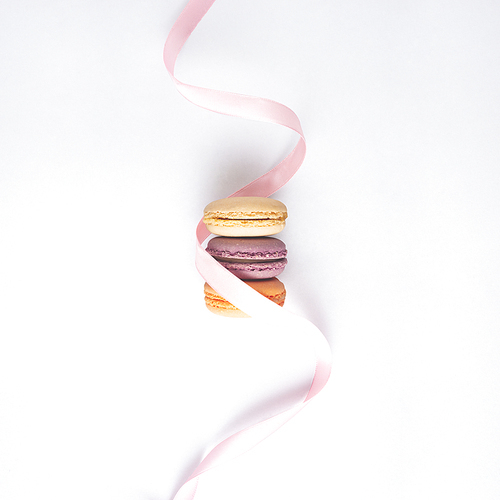 Creative concept still life food diet health photo of macarons macaroons pastry almond sweet confectionary with silk ribbon on white background.