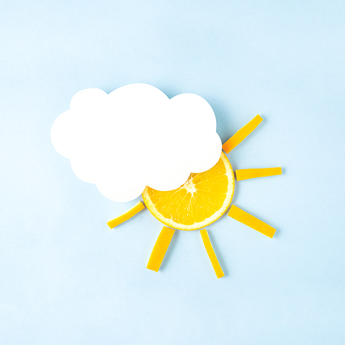 Creative concept still life food diet health photo of orange raw slice in shape of the sun with cloud made of paper on blue background.