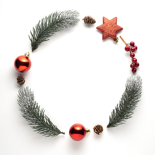 Creative concept still life holiday Christmas photo of pine tree branches and berries in the shape of wreath on white background.