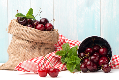 Cherries in small bag on the wooden table.