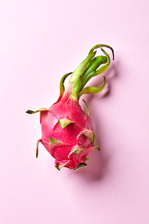 A fresh exotic fruit pitahaya on a pink background with copy space. Healthy tropical fruit. Top view.