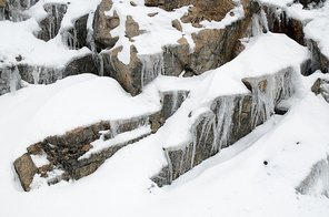Snow and ice covering granite rocks.