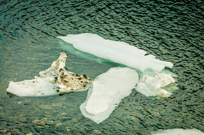 Ice fragments in river or lake water. Dark blue natural background