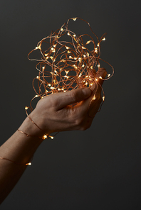 Christmas lights.Female hands holding a garland with lights on a black background