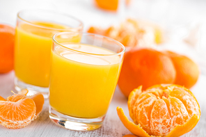 Tangerines, peeled tangerines and tangerine juice in glass. Mandarine juice.