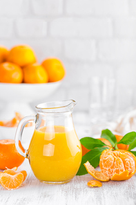 Tangerines, peeled tangerines and tangerine juice in glass. Mandarine juice.