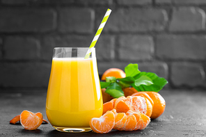 Tangerines, peeled tangerines and tangerine juice in glass. Mandarine juice and fresh fruits with leaves.