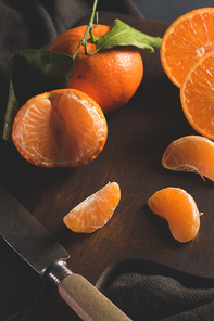 Fresh mandarin oranges or tangerines with leaves on textured dark background