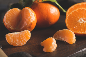 Fresh mandarin oranges or tangerines with leaves on textured dark background