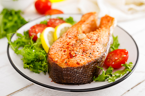 salmon fish steak grilled and fresh  salad with tomato and lettuce. healthy food. top view