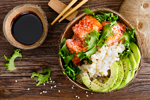 hawaiian poke coconut bowl with grilled salmon fish, food and avocado. healthy food. top view