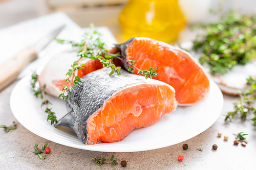 Fresh raw salmon fish steaks on white kitchen background