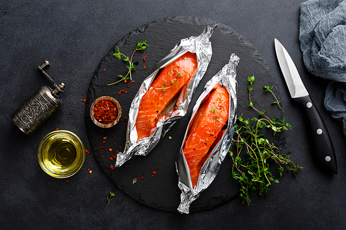 raw salmon fish fillet in foil on  background