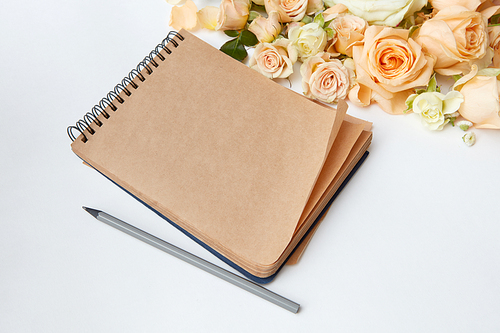 note pad with pen and beautiful bouquet on a white background ,