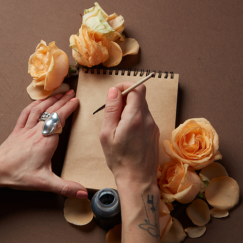 Women's Day concept. Valentine's Day concept. Diary or notebook with yellow roses around for ideas and expressing emotions. Blank copy space for writing congratulations.