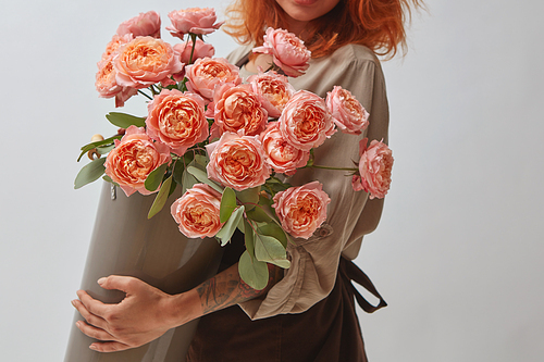 pink roses in a vase, the girl is holding a vase of flowers in her hands, flowers shop concept, mothers Day,